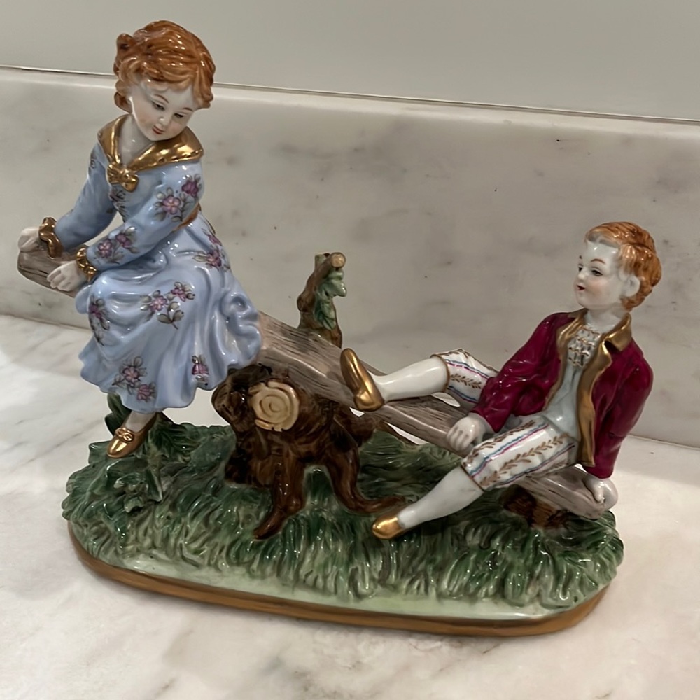 Lovely Porcelain figurines on seesaw
